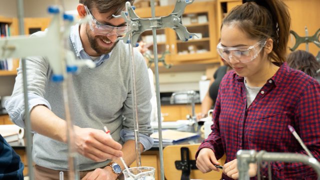 Chemistry professor assisting student in a lab
