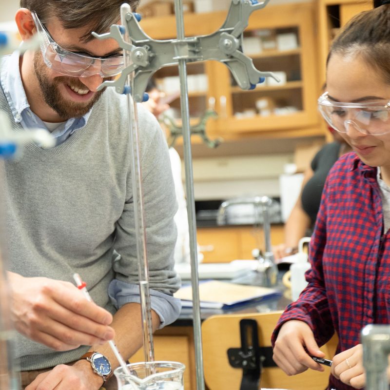 Chemistry professor assisting student in a lab