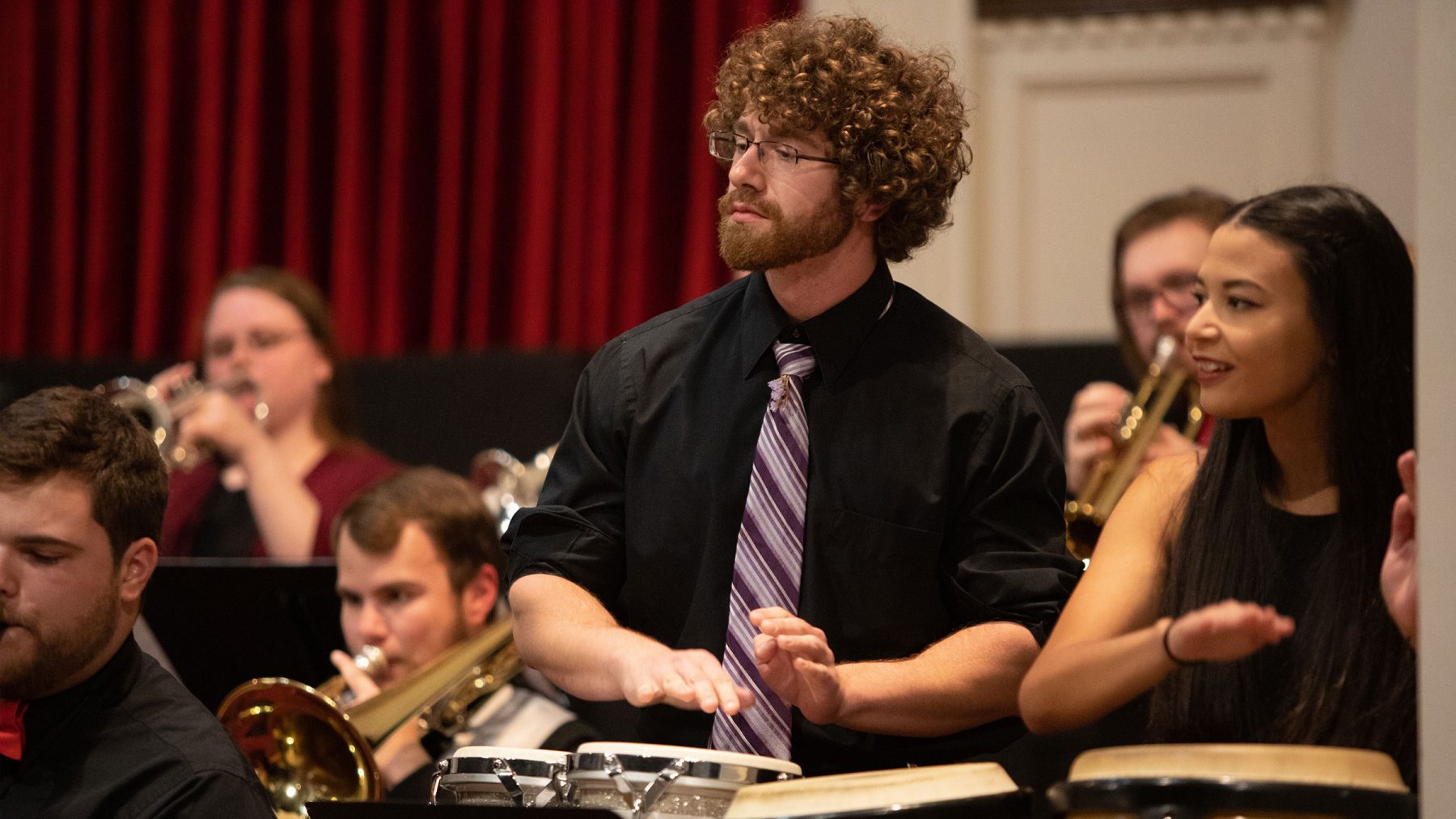 Male and female student playing bongos during a concert