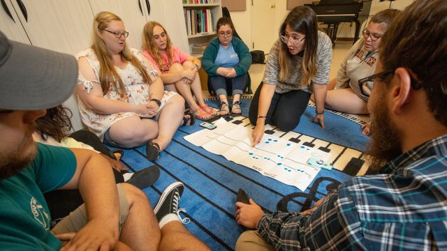 Students study music while sitting on the floor