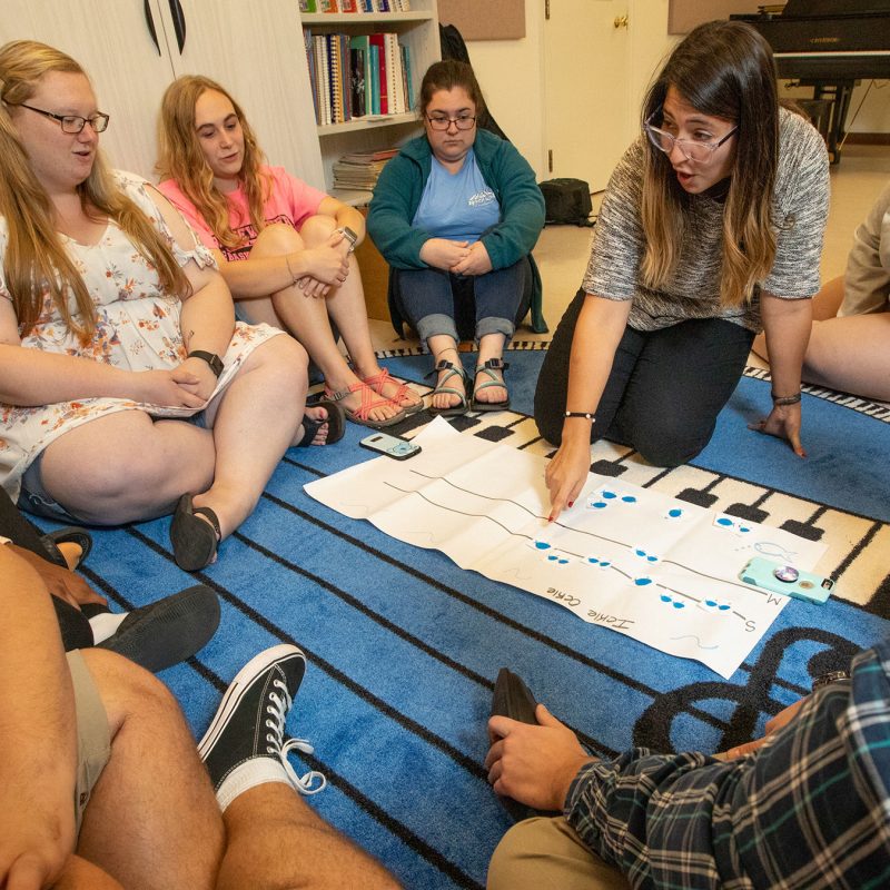 Students study music while sitting on the floor