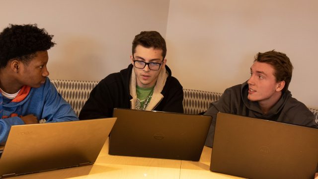 Three male students with laptops