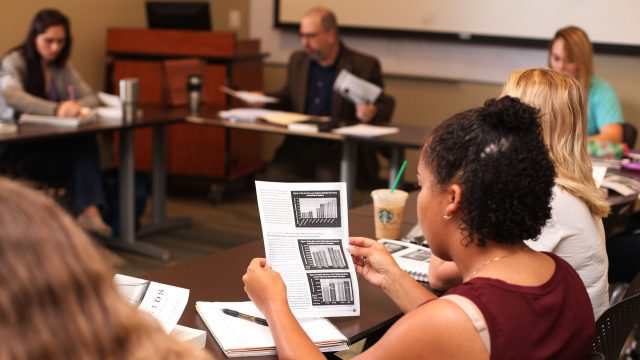 Female student reviews a paper in class