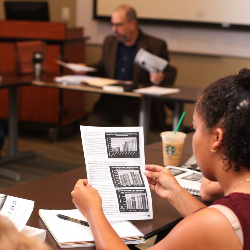 Female student reviews a paper in class