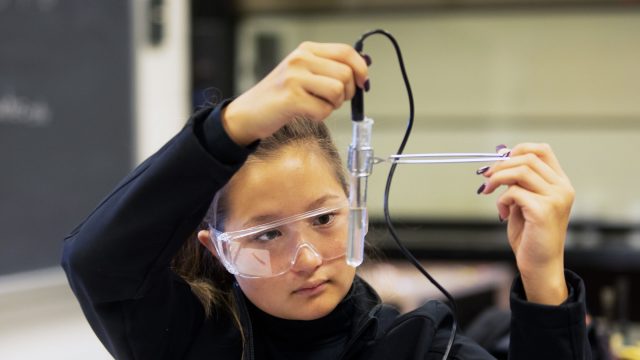 Female student studying test tube