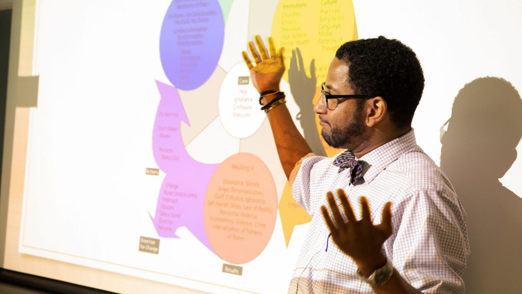 Professor stands in front of presentation