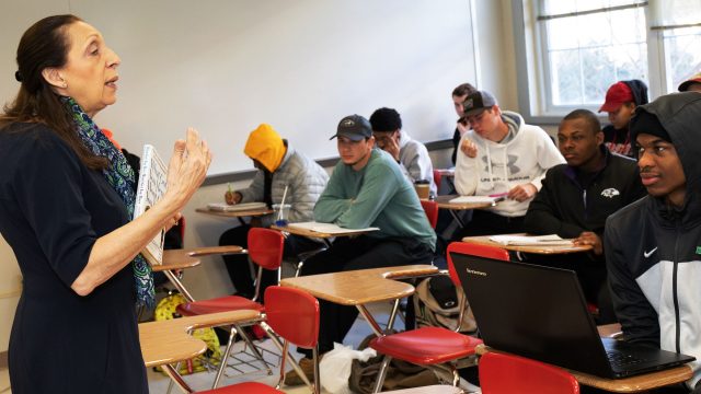 Female professor instructs class of students