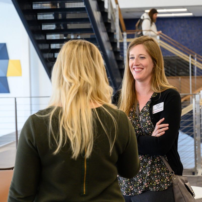 Two female staff members talking inside the Forrer Learning Commons