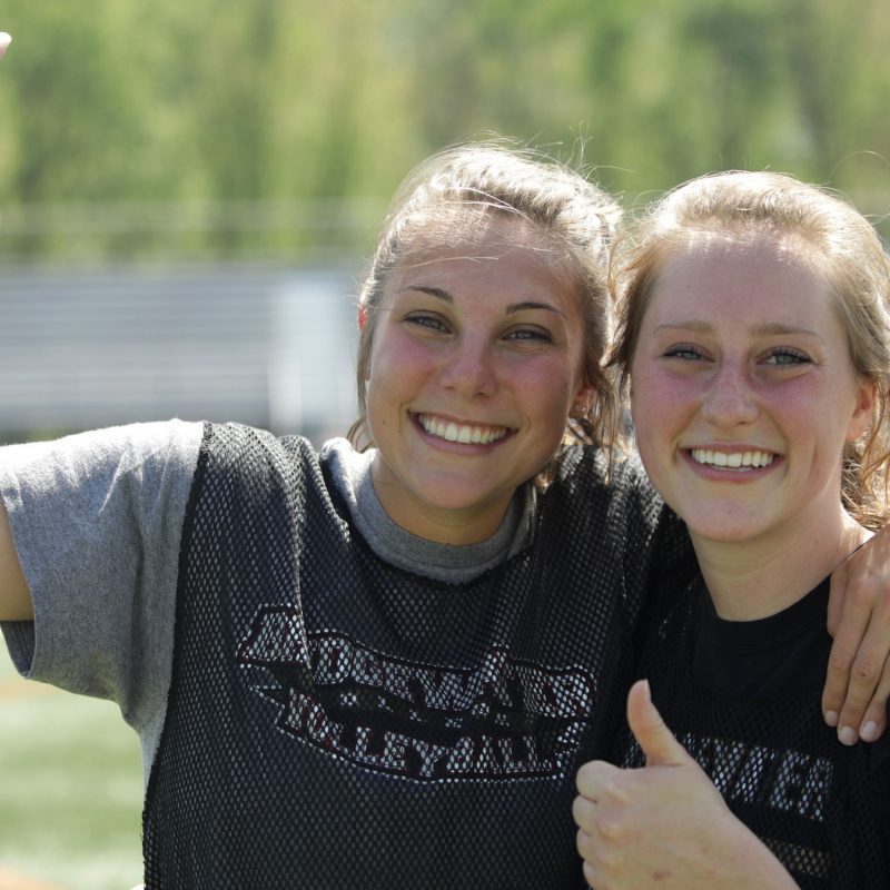 Two female student athletes on the football field