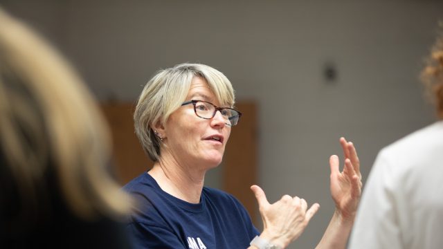 Female instructor speaks with students