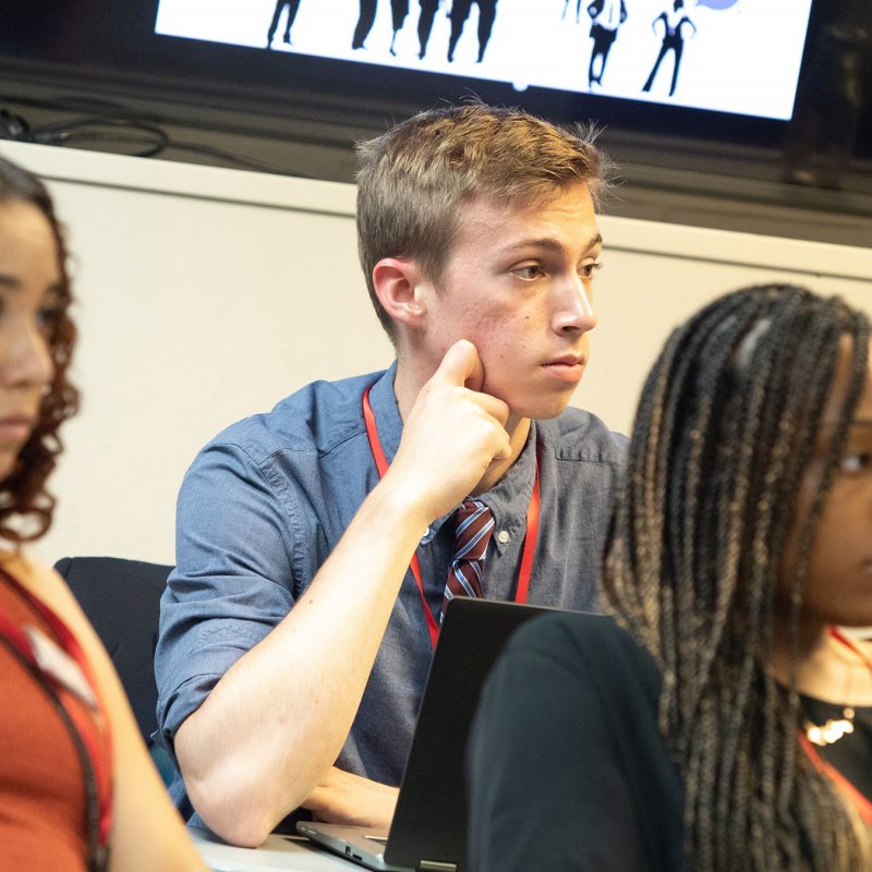 Three students listening in classroom.