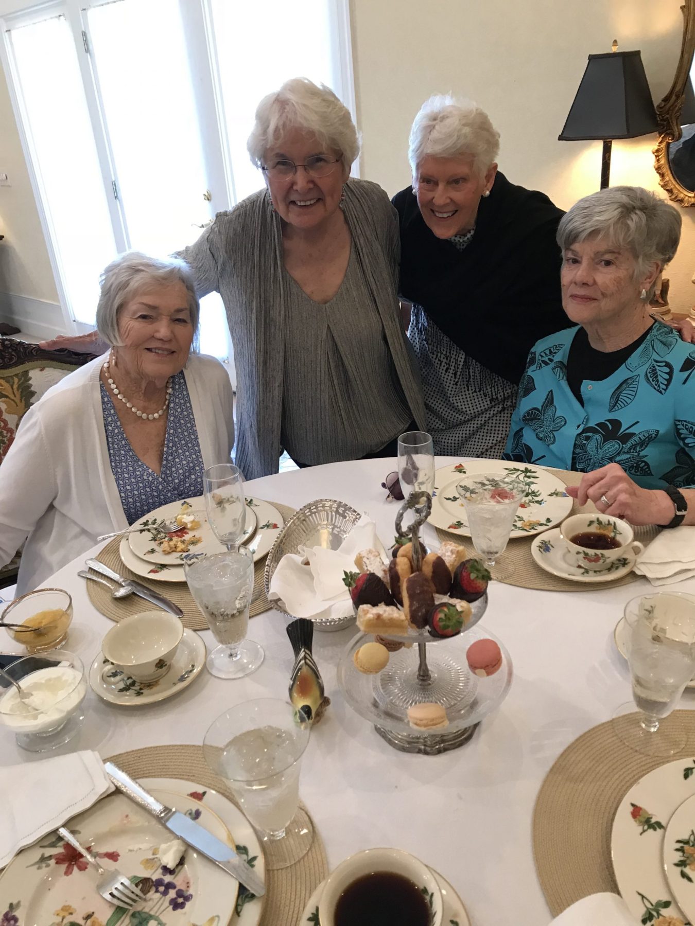 Four older women sit around a table