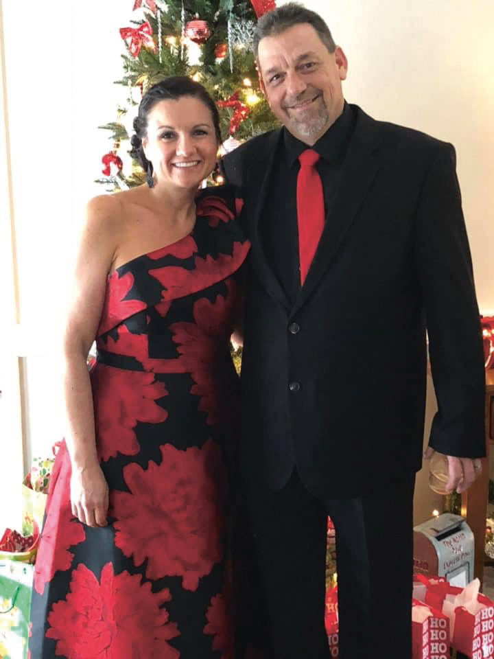 Woman in red dress stands next to man in tux