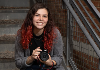 Courtney Hawkins holds a camera|Courtney Hawkins holds a camera|Courtney Hawkins holds a camera