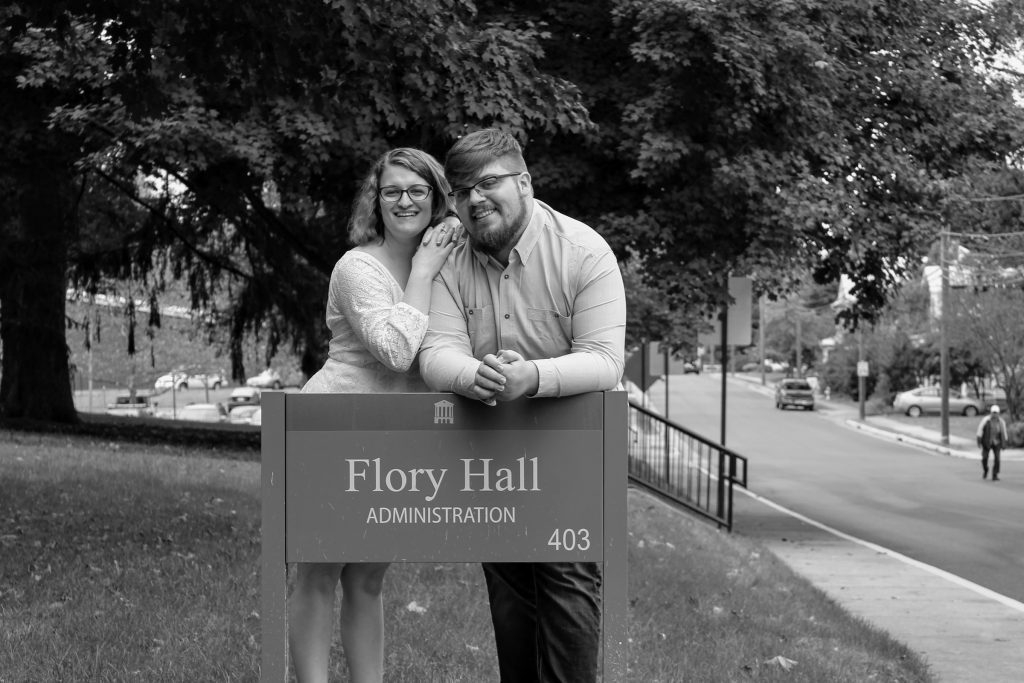 Man and woman stand behind sign that says Flory Hall