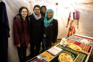 Four students stand in front of a table with food