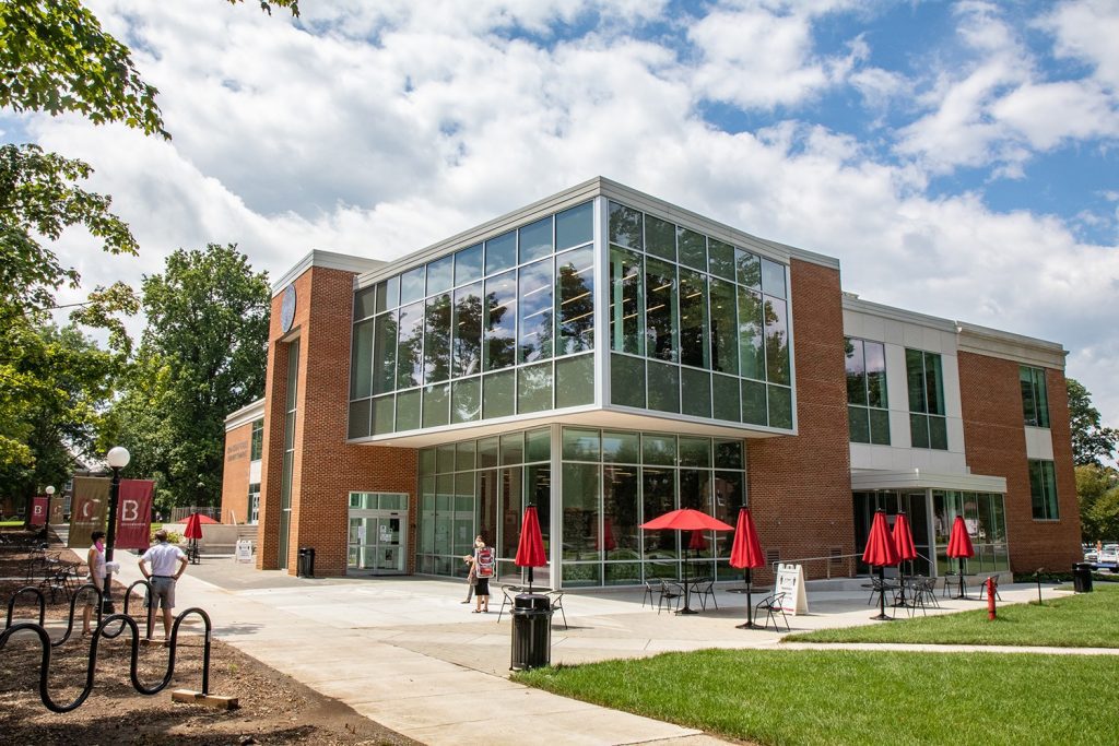 Photo of building with glass windows and people walking in front of it