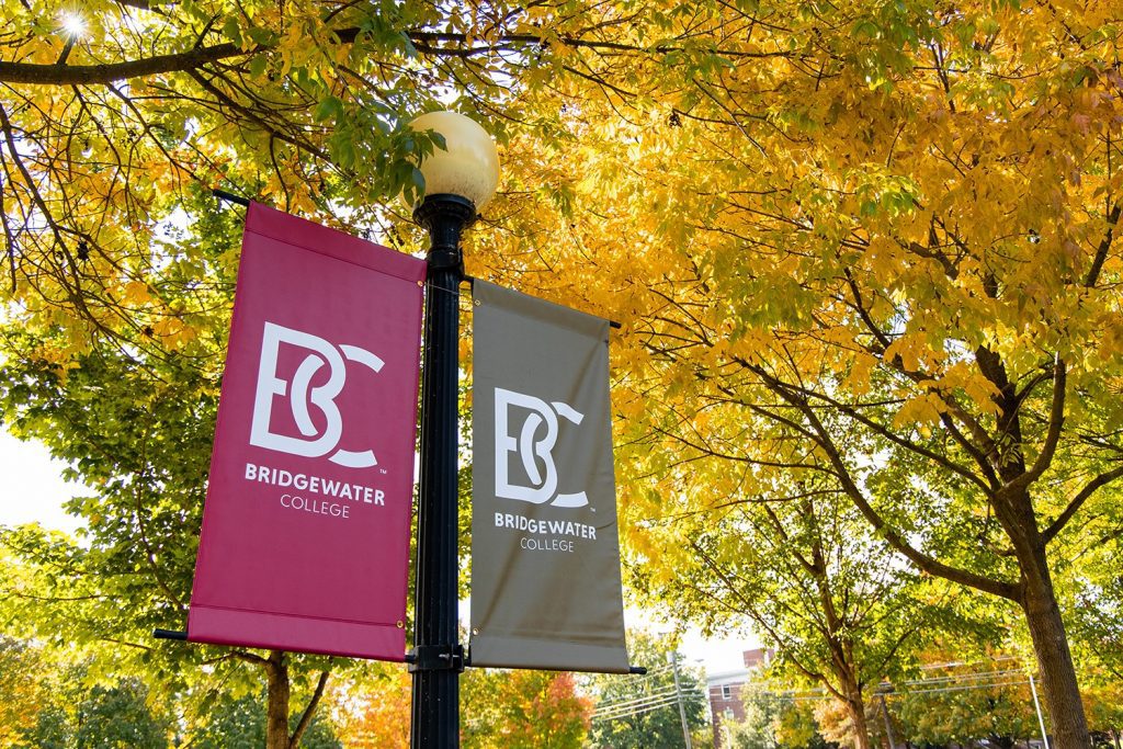 B-C banner flags on campus with fall leaves