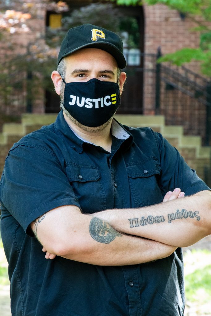 man wears a mask with the word justice