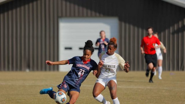 Two women soccer players fighting for possession of the soccer ball