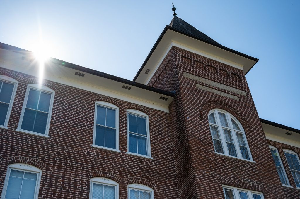 On-Campus brick building with sun peaking over the roofline