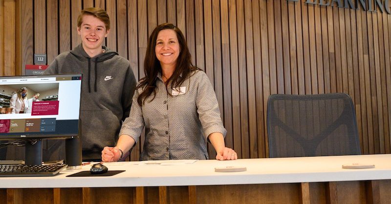 Man and woman standing at a desk smiling for a photo