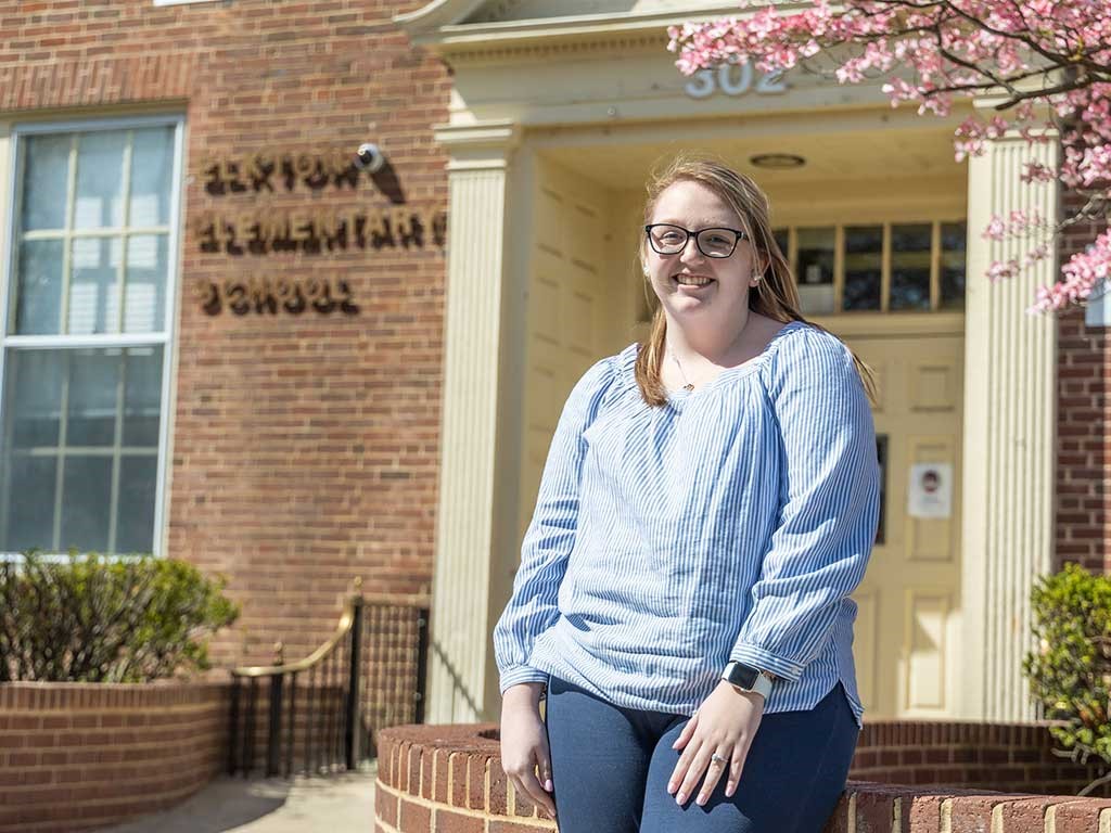 Female pictured in front of brick building