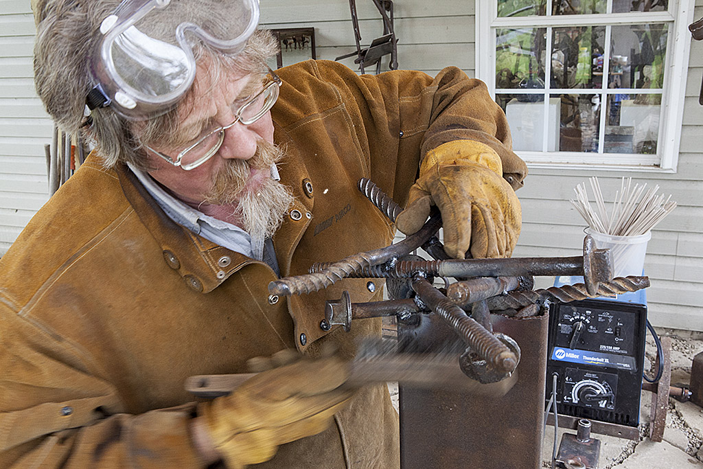 Bridgewater College Associate Professor of Art Michael Hough welds a metal sculpture