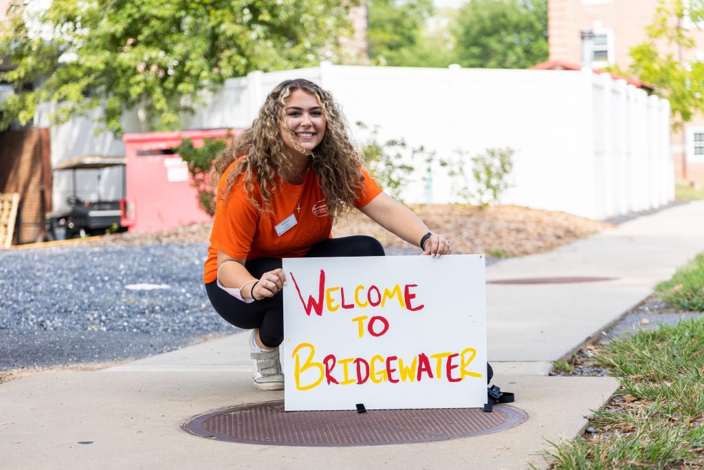 A Bridgewater students holds a sign that says "Welcome to Bridgewater"