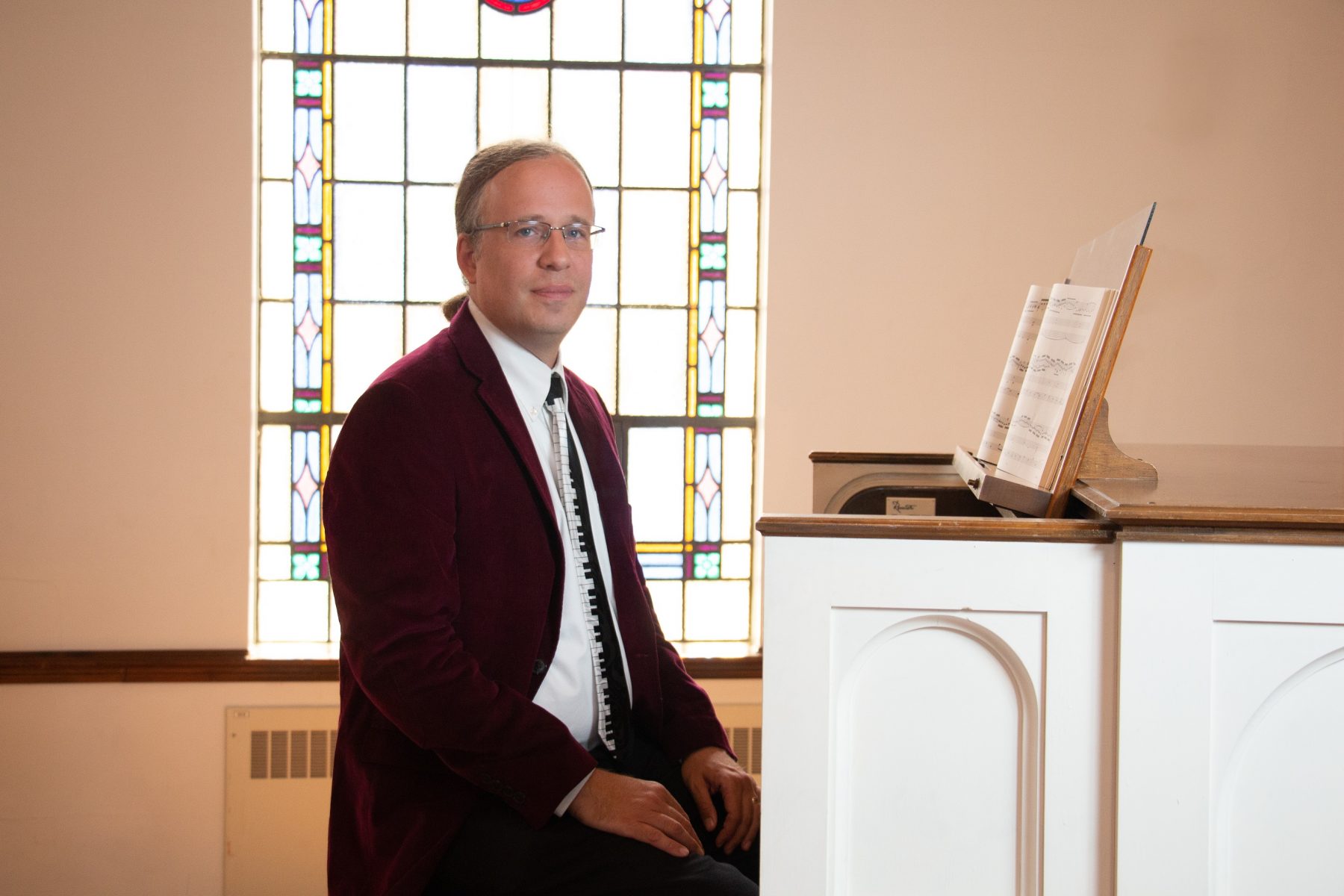 Professor of Music Larry Taylor sitting at a piano