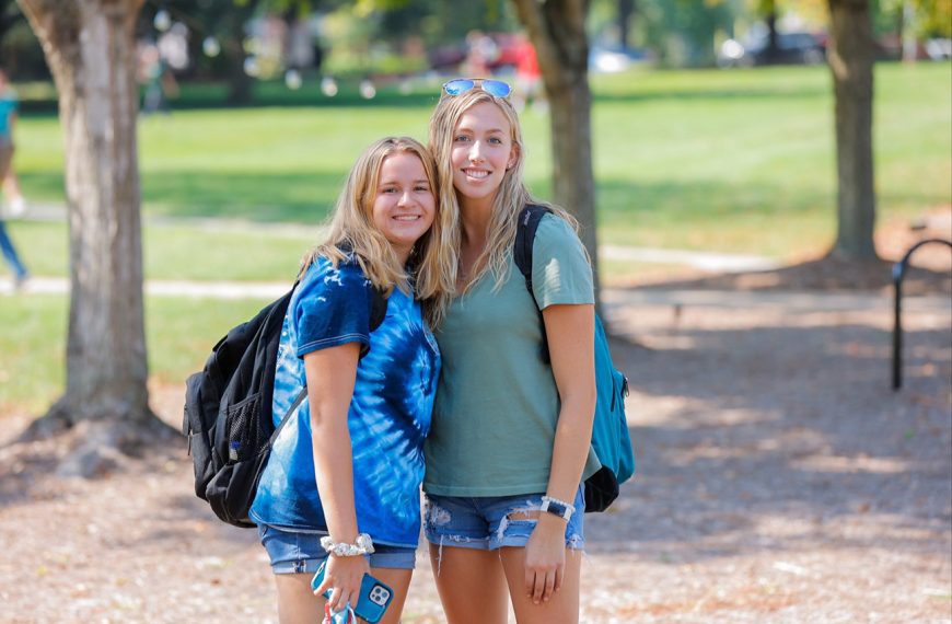 Two girls hug and smile on the first day of classes 2021