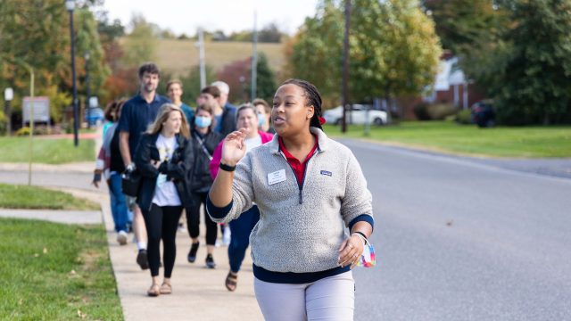 Student tour guide leading a group around campus