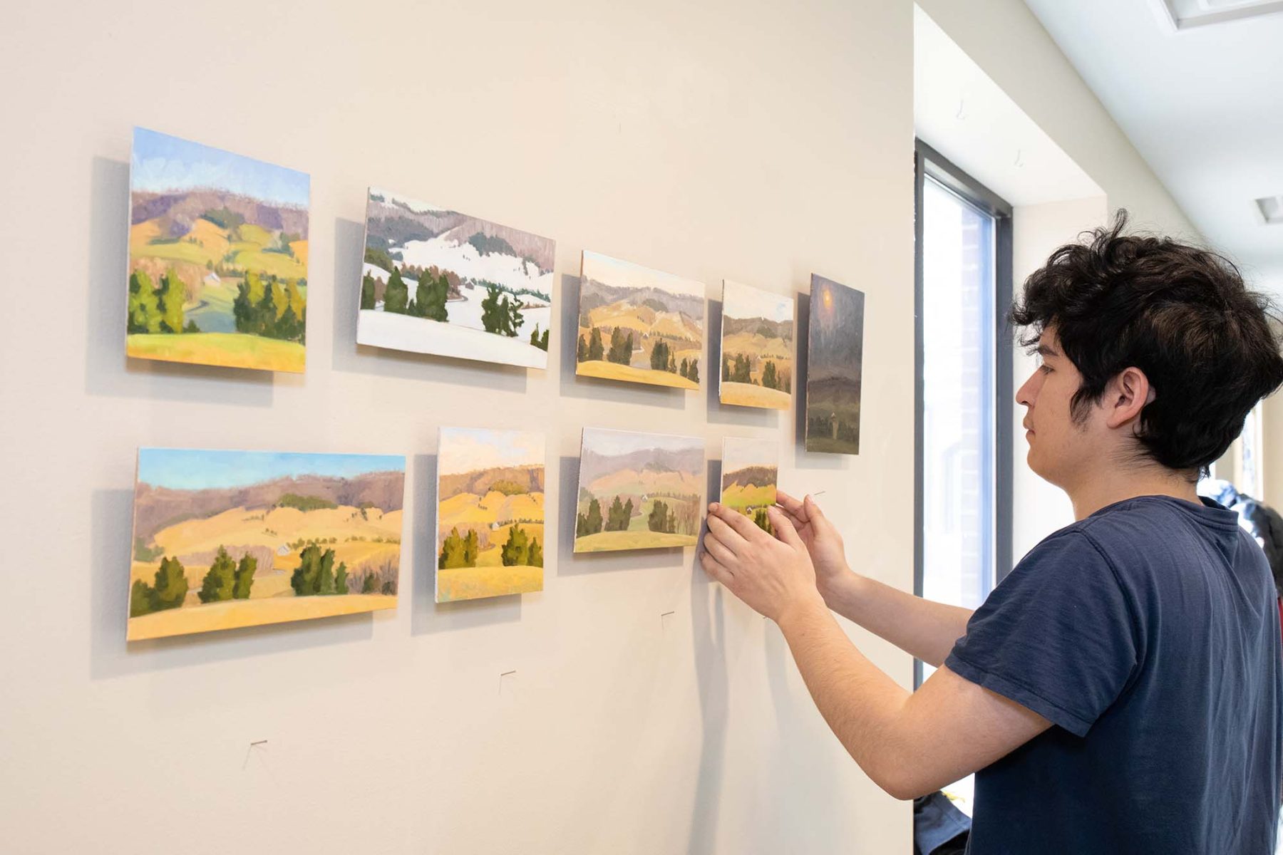 Student hanging landscape art