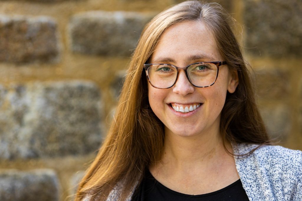 A headshot of writer Emma Green. She appears wearing glasses and smiling.