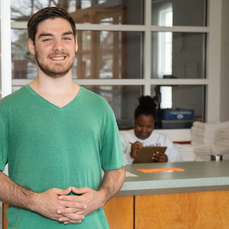 Lane Salisbury standing in front of counter with a green shirt