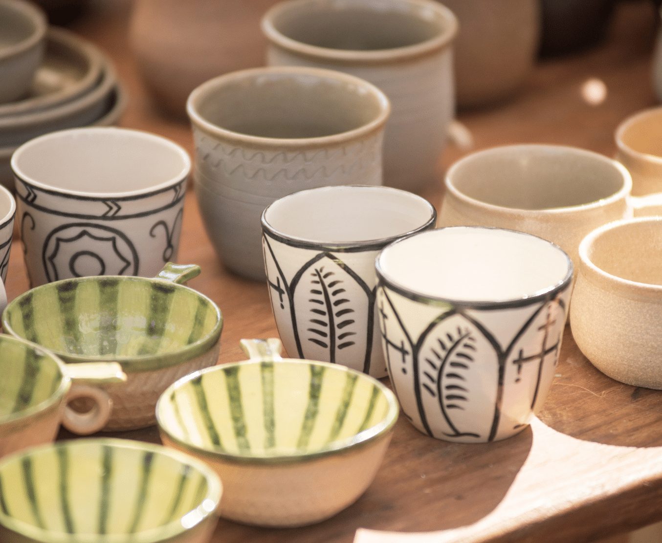 green, blue and white cups and bowls lined on a table