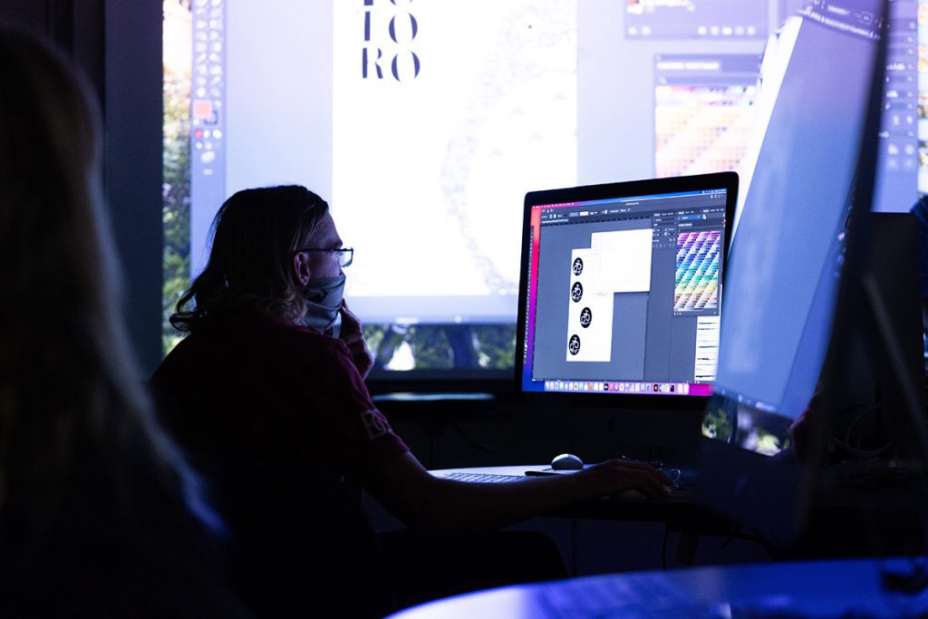 Student sits in a dark room in front of a computer