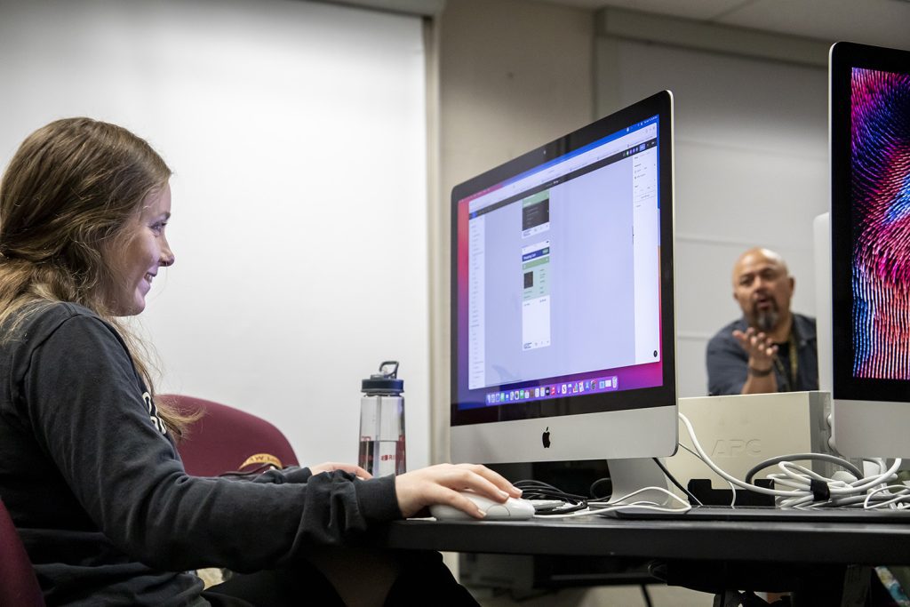 Female digital media strategy student working on Mac desktop
