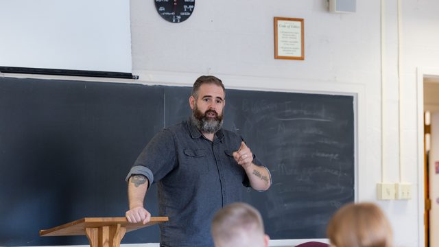 Professor at the front of the classroom teaching students