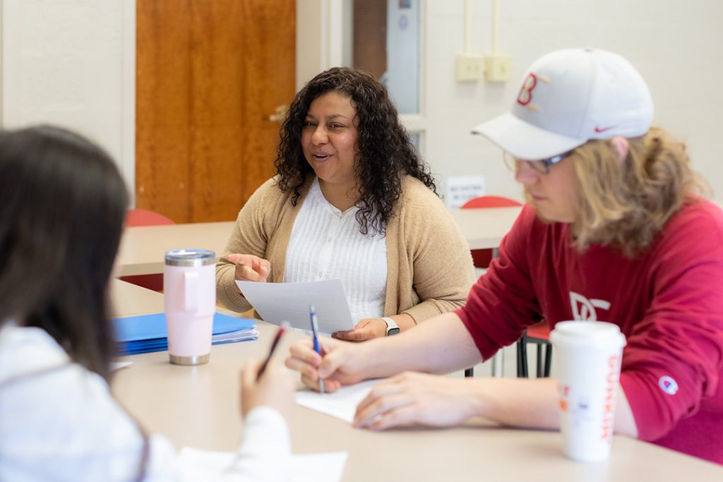 Professor sitting with students during class