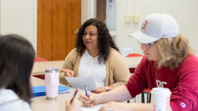 Professor sitting with students during class
