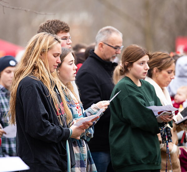 Group of people sing together at remembrance event