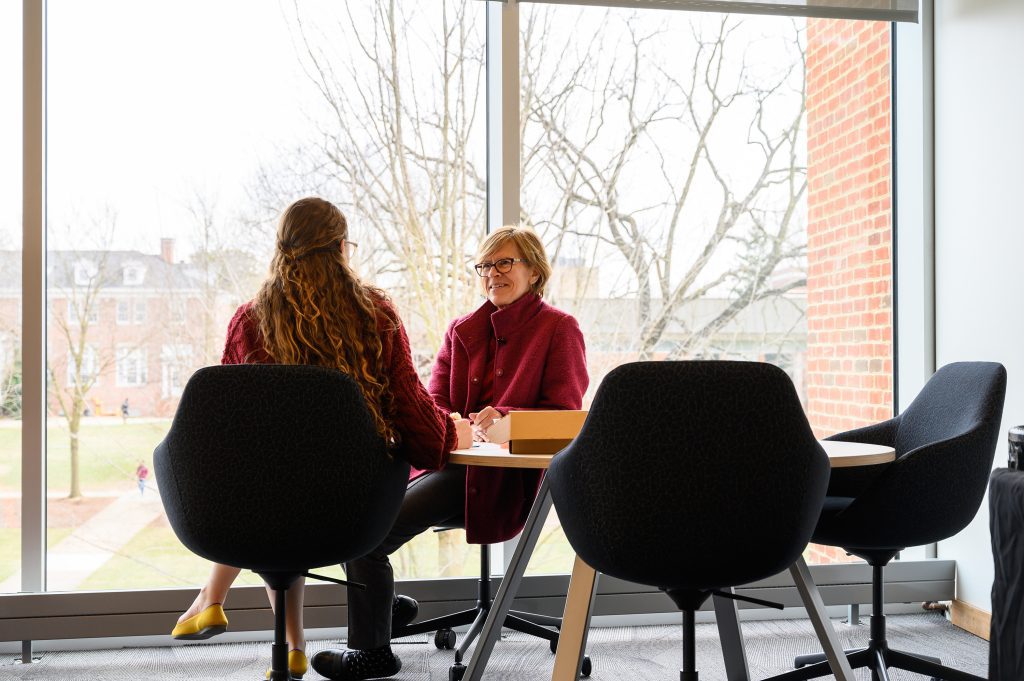 2 people sitting at a table talking