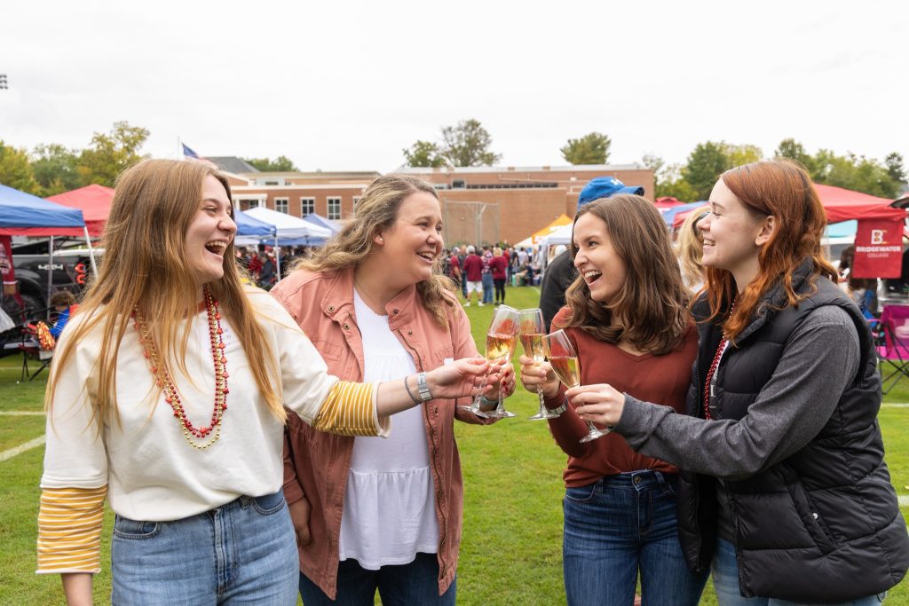 4 women laughing while toasting with champagne flutes