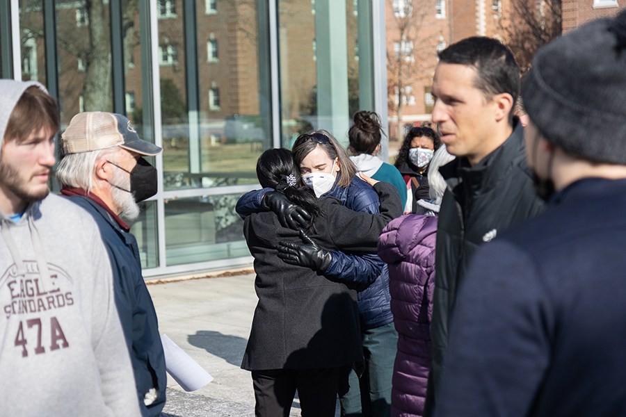 Bridgewater College staff members hug in front of the Forrer Learning Commons