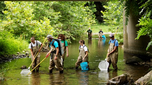 Student wading in the North River