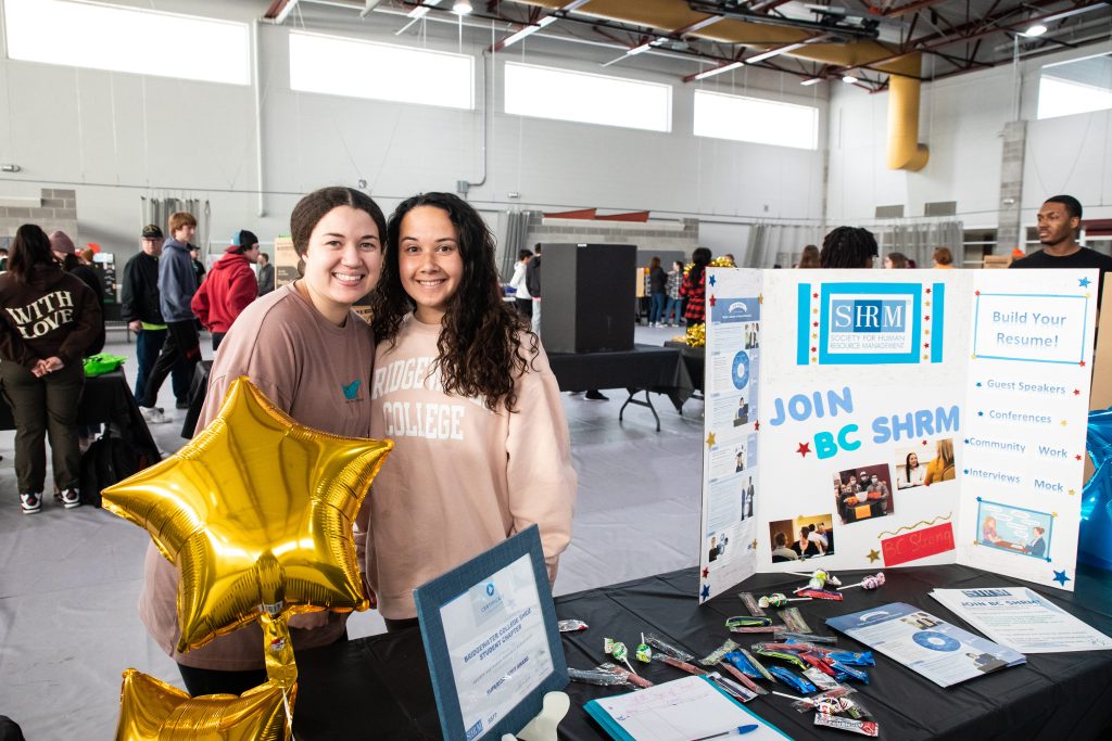 Two students standing next to poster