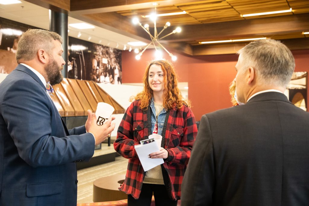 Female student in the middle talking to two men