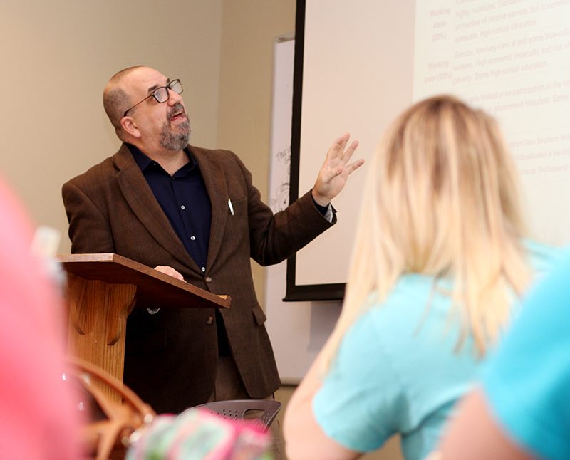 Professor pointing to displayed projector in class