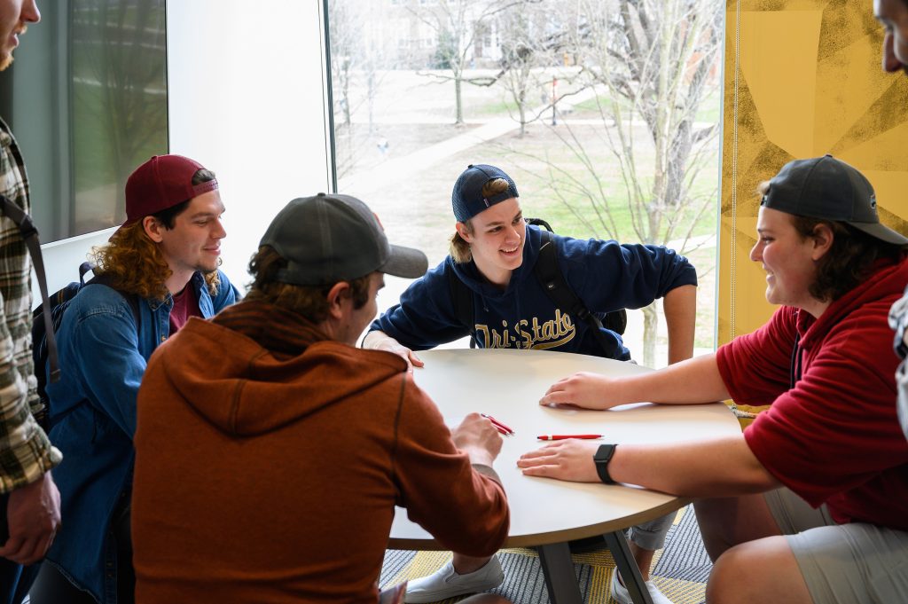 A group of 5 students sitting around a table